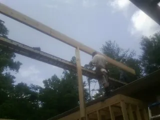 Carpenter setting a ridge beam over a new addition frame — Ice Dam Removal by Roofing Brothers in Flat Top