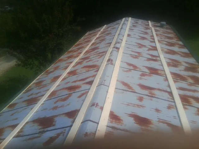 Rusted metal roof panels with new wood purlins before replacement — Storm Damage Roof Repair in Flat Top by Roofing Brothers