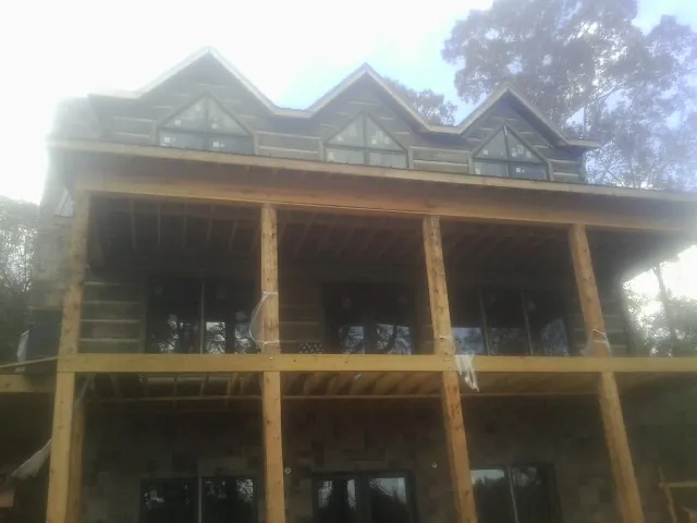 Dormers and porch framing on a large log home under construction — Roof Coating work by our crew in Flat Top